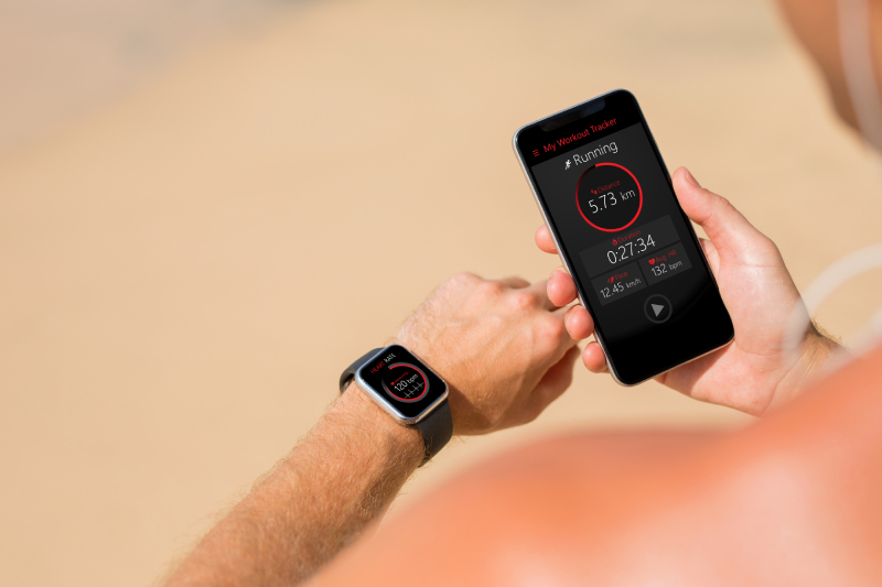 A person comparing his vital signs readings on iphone with an Apple watch tied around is wrist.