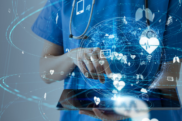 A doctor holding a mobile phone, touching the screen with the other hand and a virtual image of a globe shown above the mobile along with medical technology related icons revolving around it.