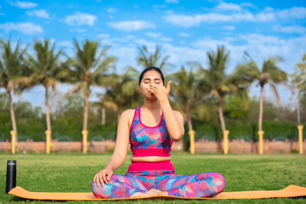 A young woman is doing yoga in a natural environment.
