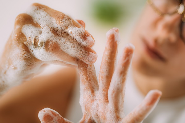 A close-up shot of hands covered in soap suds, highlighting the importance of hygiene and cleanliness.