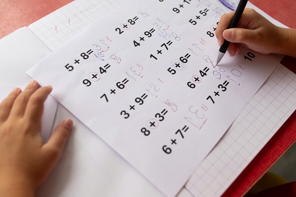A child's math homework with dyslexia, showing numbers written backwards and jumbled on the page.