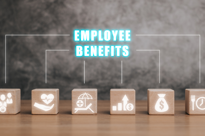 A wooden block on a desk with the Employee Benefits symbol glowing on a virtual interface.