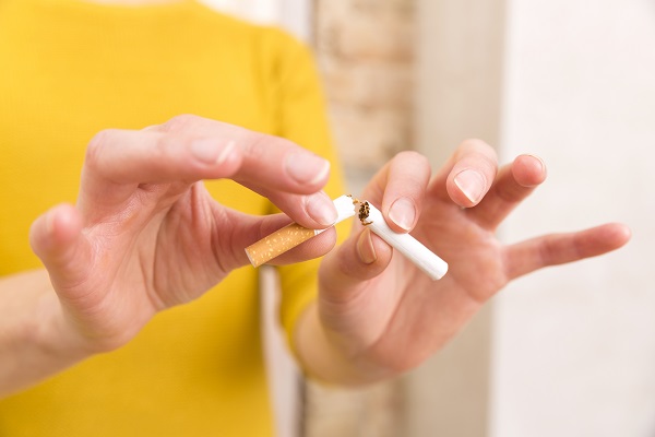 A person breaks a cigarette, symbolizing self-awareness and the decision to quit smoking.