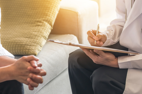 A patient consulting with a doctor for a health examination, emphasizing the importance of informing your counselor about mental health apps.