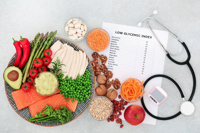 Low glycemic foods, along with a pedometer and stethoscope, show how these options help manage diabetes in a balanced meal plan.