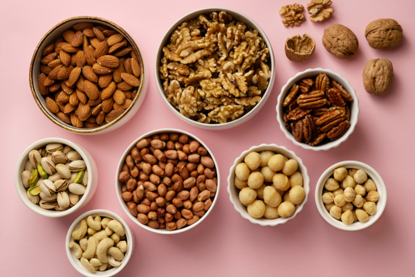 A variety of nuts in bowls, rich in healthy fats and phytosterols, supporting cholesterol management.