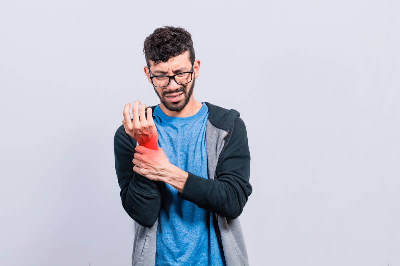 A man experiencing severe wrist pain, emphasizing the importance of identifying arthritis early for proper treatment.