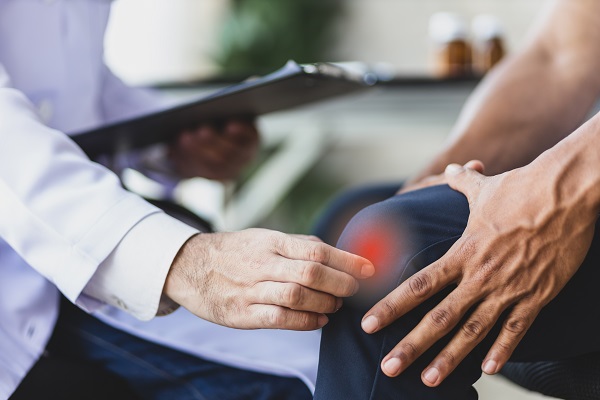 A medical professional examining a patient's medical history and pain symptoms to diagnose arthritis.