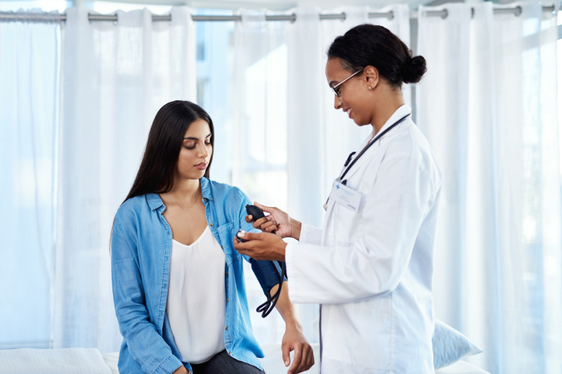 Doctor measuring a patient's blood pressure, indicating high arterial pressure.