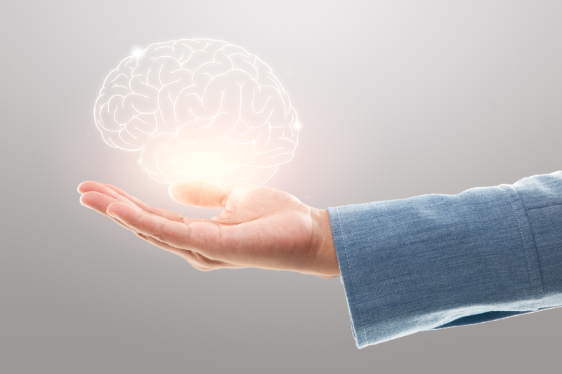 A person holding a digital brain, representing the importance of brain health for overall wellness.