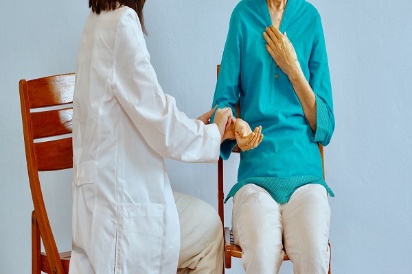A doctor checks a patient's pulse during a speech therapy session.