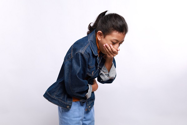 A young girl holding her stomach and covering her mouth, showing nausea as a possible high blood pressure symptom.