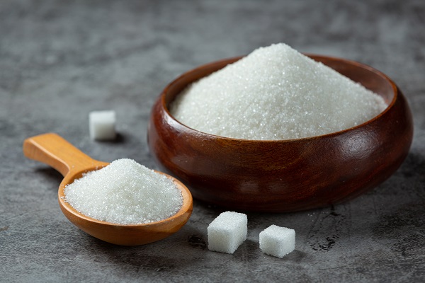 Bowl, spoon, and sugar cubes represent refined sugar’s connection to arthritis pain and swelling