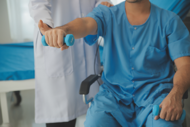 A physiotherapist guiding a patient in a dumbbell exercise to help manage arthritis-related joint stiffness.