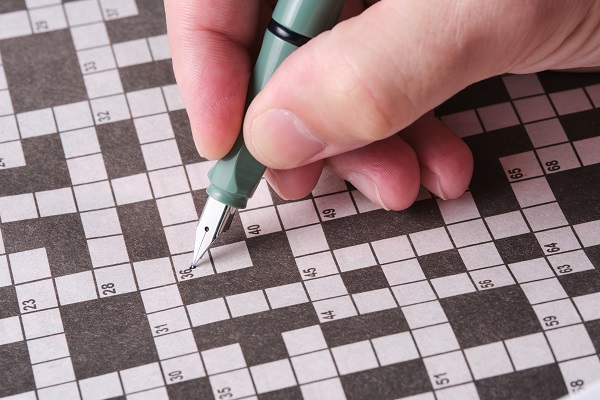A person solving a crossword reflects how mental activity may help prevent dementia.